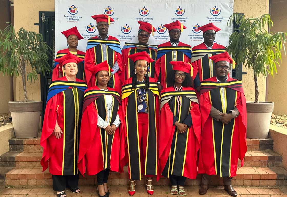 A group of TUT graduates in red and black academic dresses A group of TUT graduates in red and black academic dresses