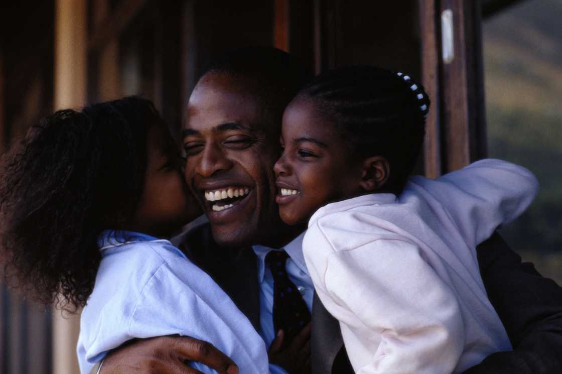 A father embracing his daughters
