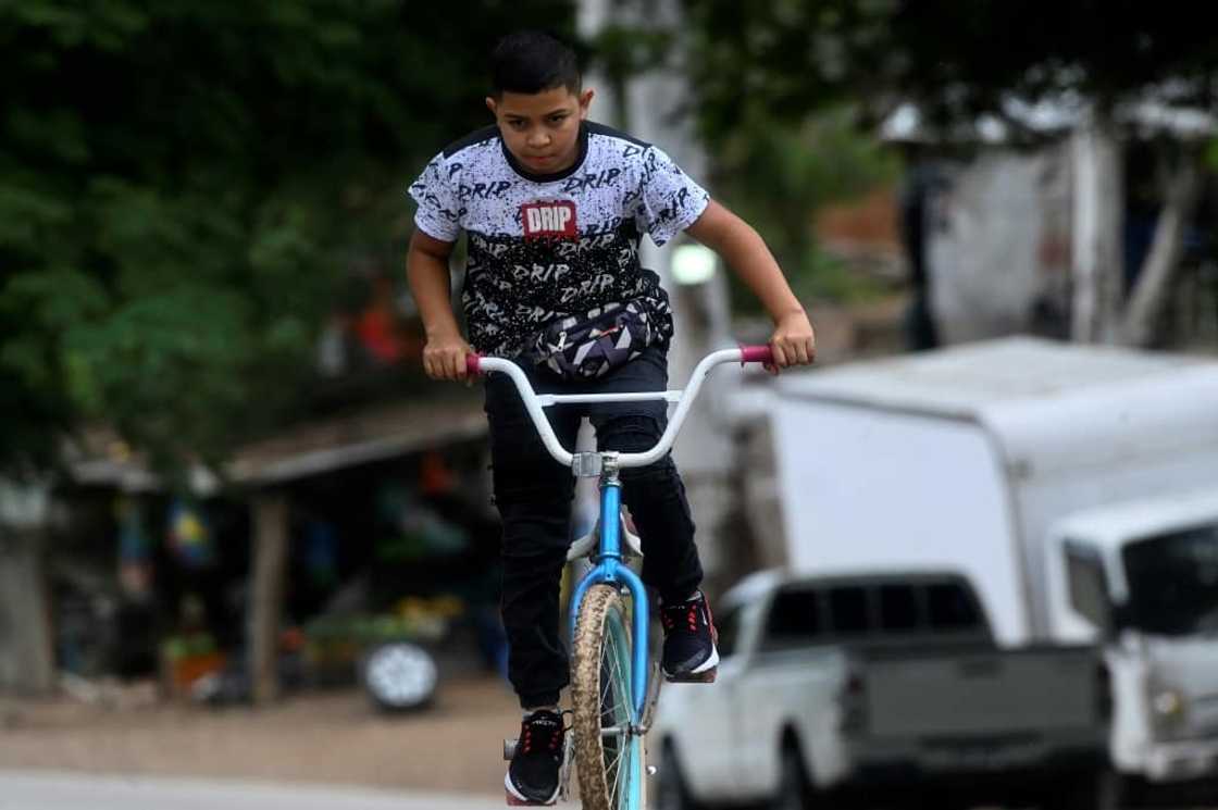 When there are no clients, Eduardo rides his bicycle or plays with his friends When there are no clients, Eduardo rides his bicycle or plays with his friends