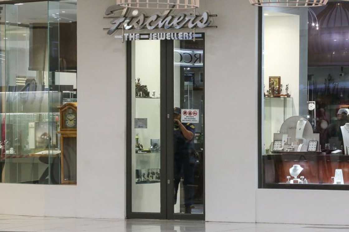 A police officer is spotted inside Fischer's at the Greenacres Shopping Centre. The jeweler store was robbed by a group or armed men.