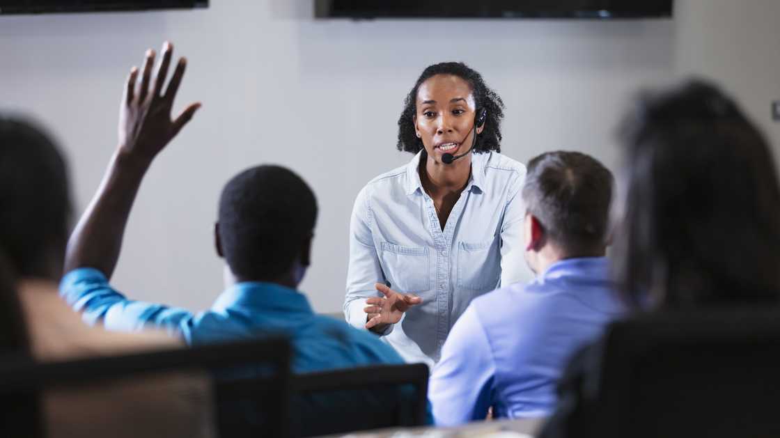 A coach stands before a group of call centre trainees during accent training. A coach stands before a group of call centre trainees during accent training.