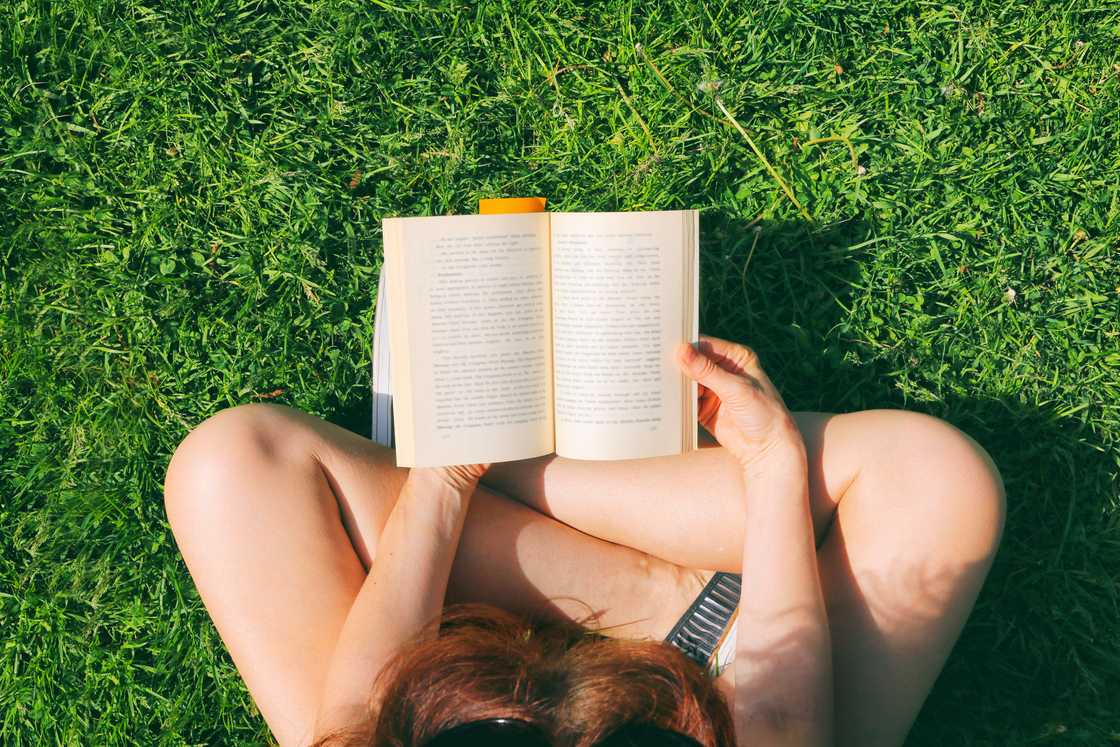 A woman reading a book in the garden. A woman reading a book in the garden.