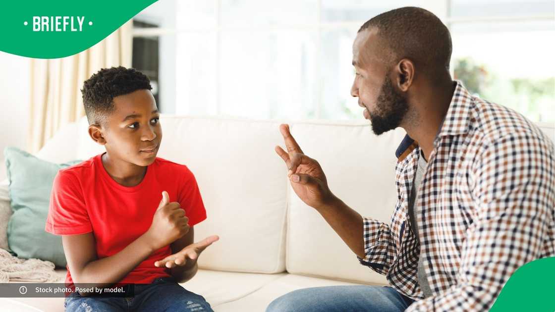 A father and son communicating in South African Sign Language.
