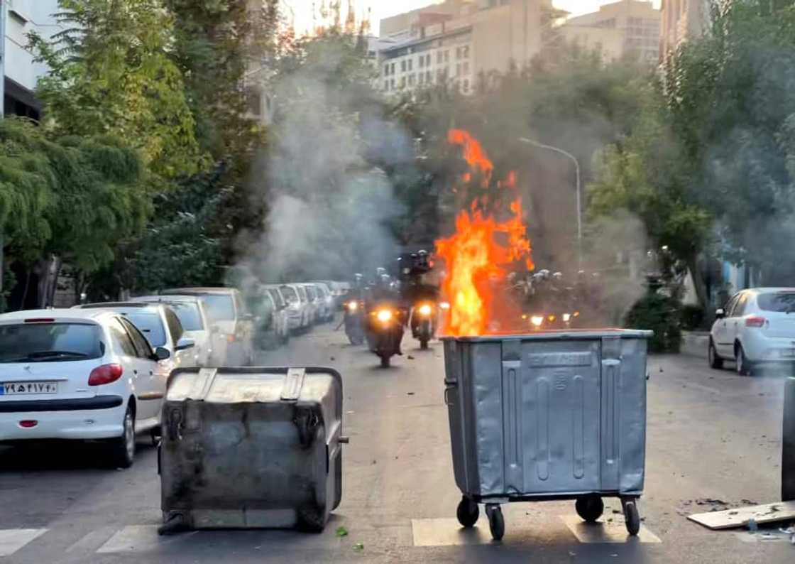 A picture obtained by AFP outside Iran shows a bin burning during a protest in Tehran on September 20, 2022