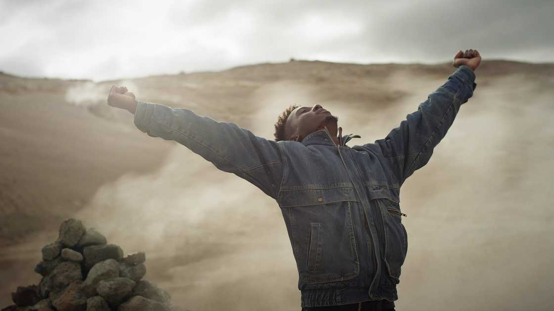 Soft close-up of hands letting go of sand or leaves in the wind