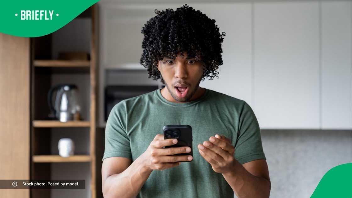 A shocked man looking at his phone.