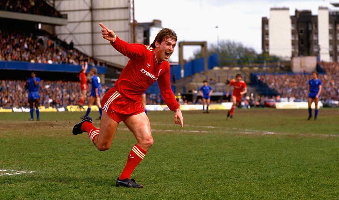 Liverpool player manager Kenny Dalglish celebrates after scoring a goal.