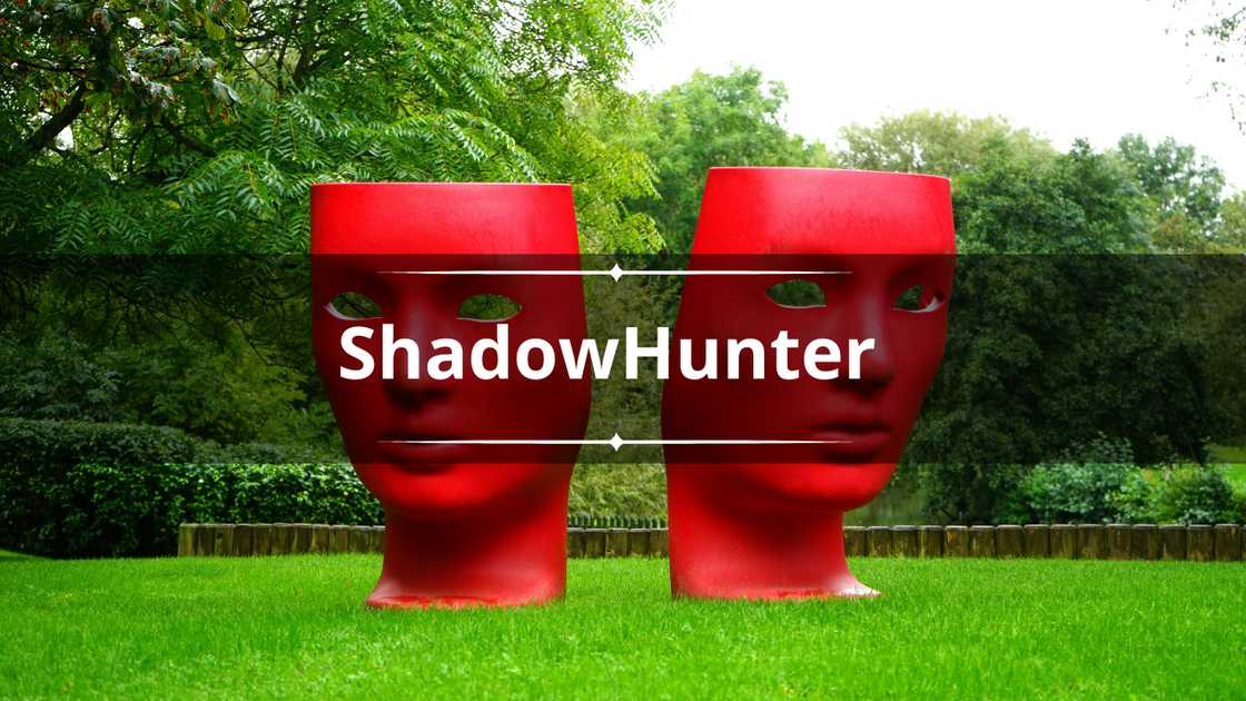 Two red human face monuments on a green grass field