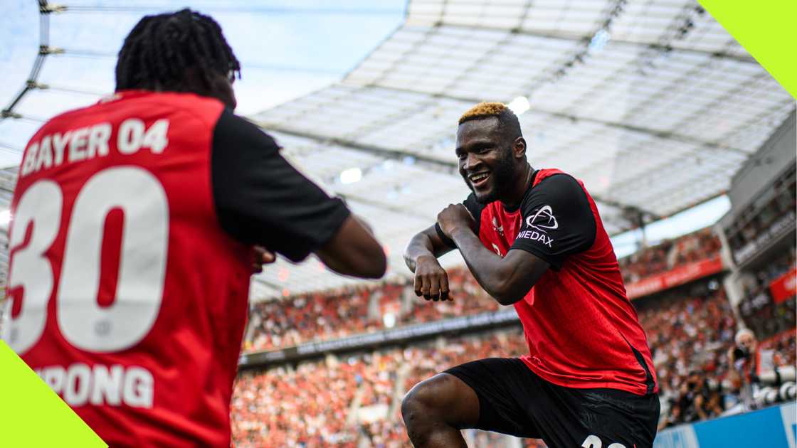 Victor Boniface celebrates with Jeremie Frimpong after scoring for Bayer Leverkusen against Wolfsburg.