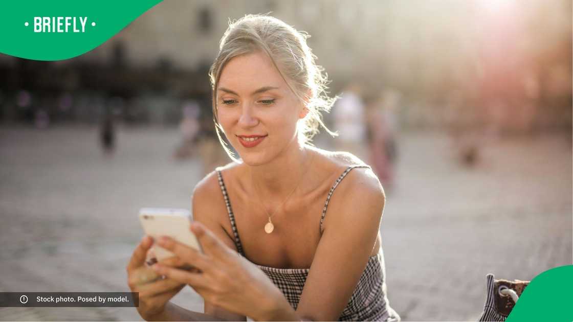 A woman smiling at her phone. A woman smiling at her phone.