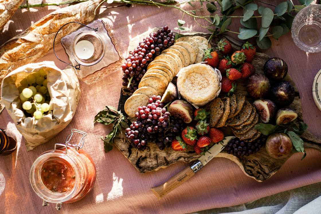 A layout of various foods on a picnic mat A layout of various foods on a picnic mat