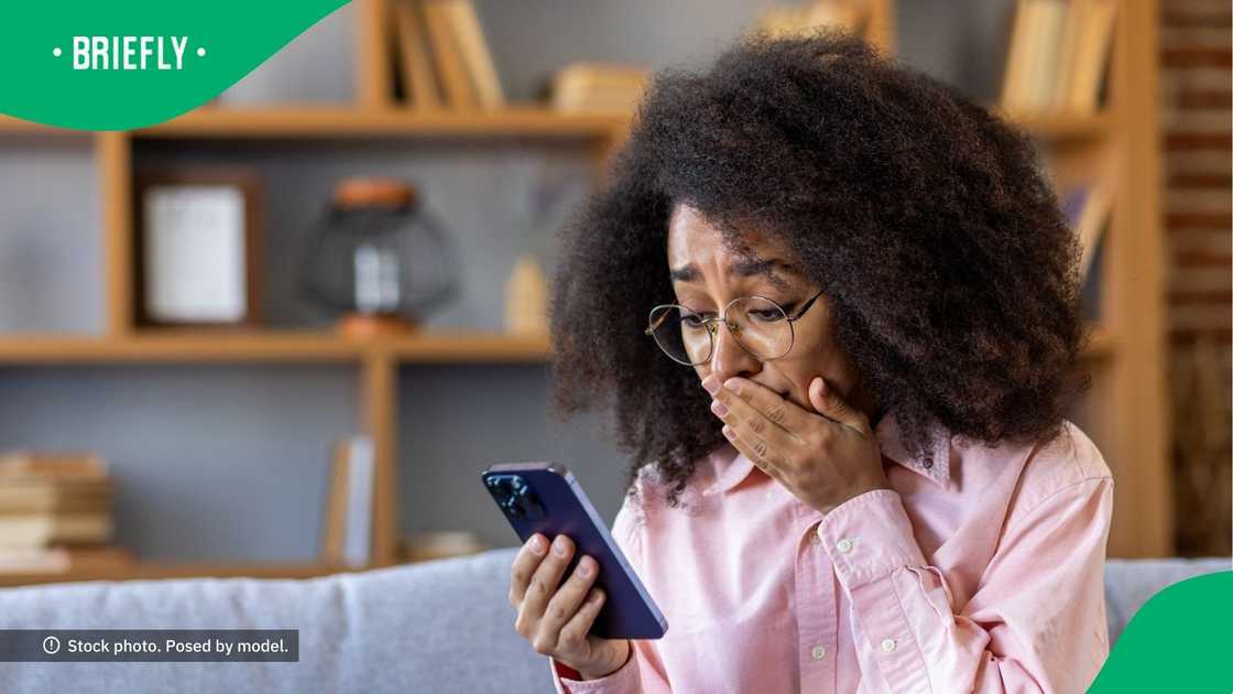 A shocked woman looking at her phone. A shocked woman looking at her phone.