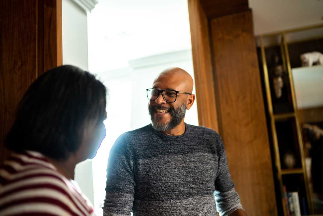 A mature man talking to a woman indoors A mature man talking to a woman indoors