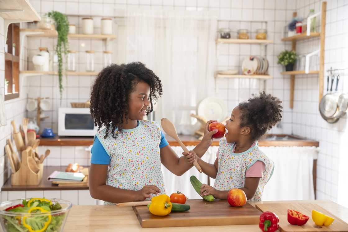 Sisters playing together in the kitchen