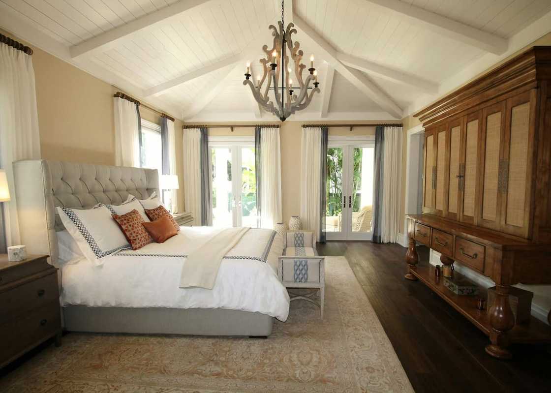 An upholstered bed near a wooden cabinet An upholstered bed near a wooden cabinet