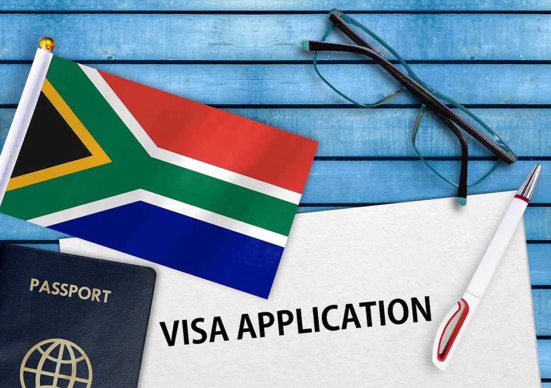 A South African flag, passport, and visa application form A South African flag, passport, and visa application form
