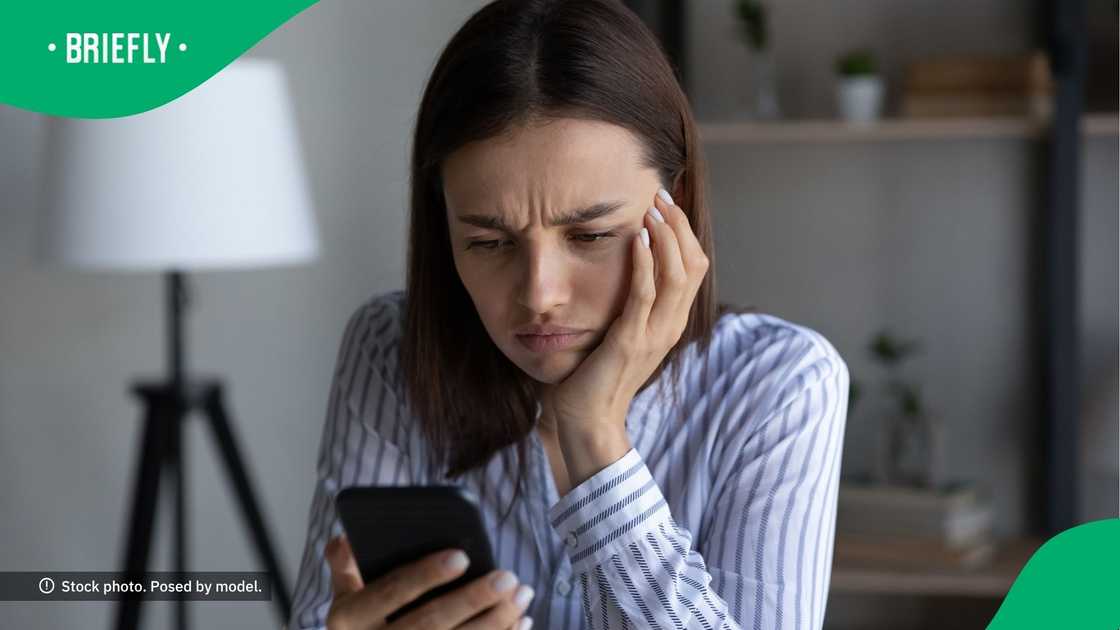 A confused woman looking at her phone. A confused woman looking at her phone.