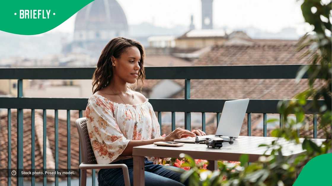 A young woman working on her laptop in Italy.