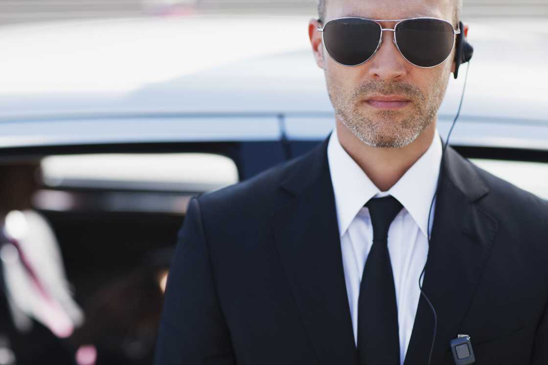 A man wearing a black suit and tie