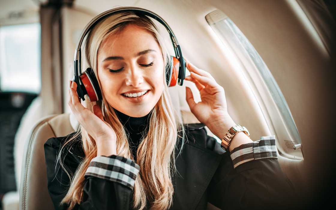 A woman listening to music in a plane A woman listening to music in a plane