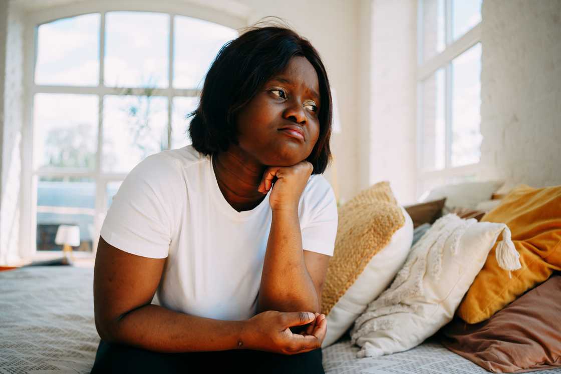 A woman sits sad and upset in the bedroom. A woman sits sad and upset in the bedroom.