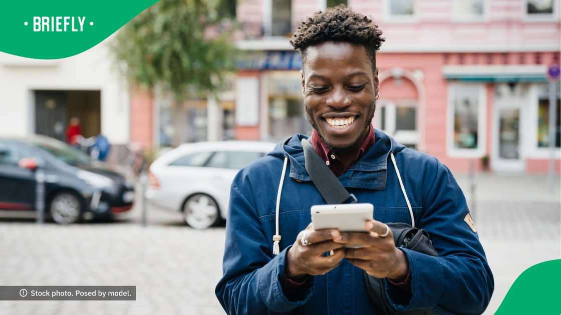 A man smiling at his phone.