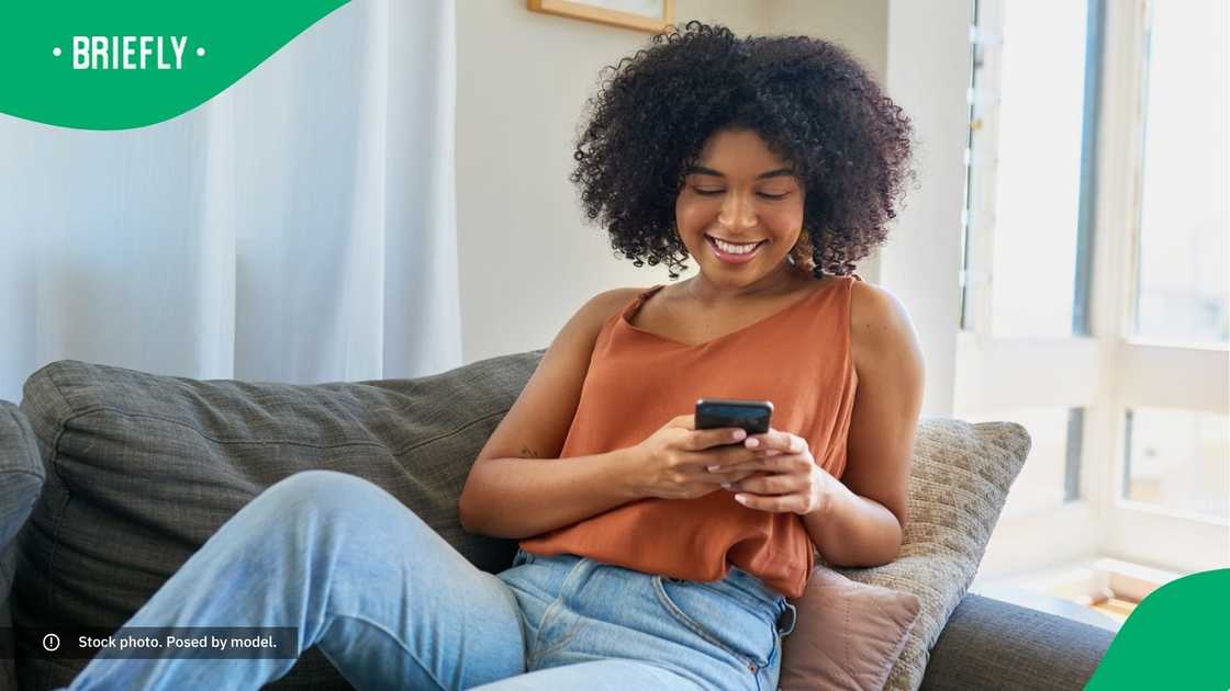 A woman smiling at her phone. A woman smiling at her phone.