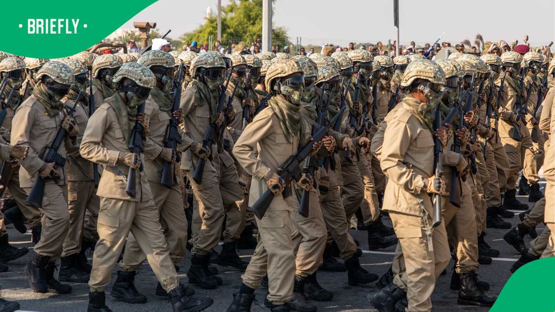 A group of women spotted some uniformed men walking through a township A group of women spotted some uniformed men walking through a township
