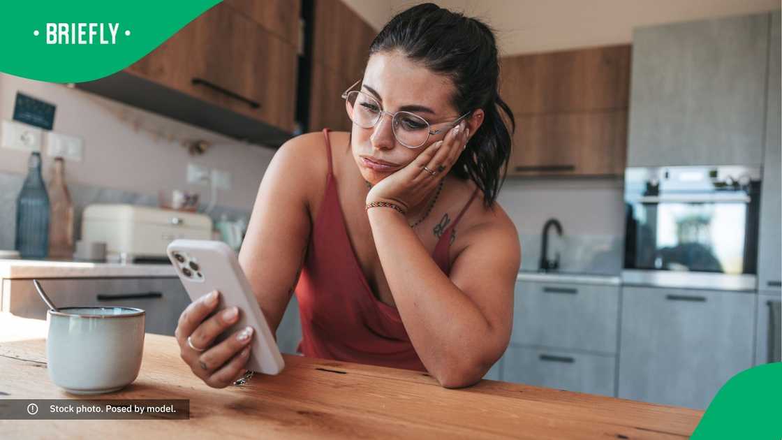 A tired woman looking at her phone.