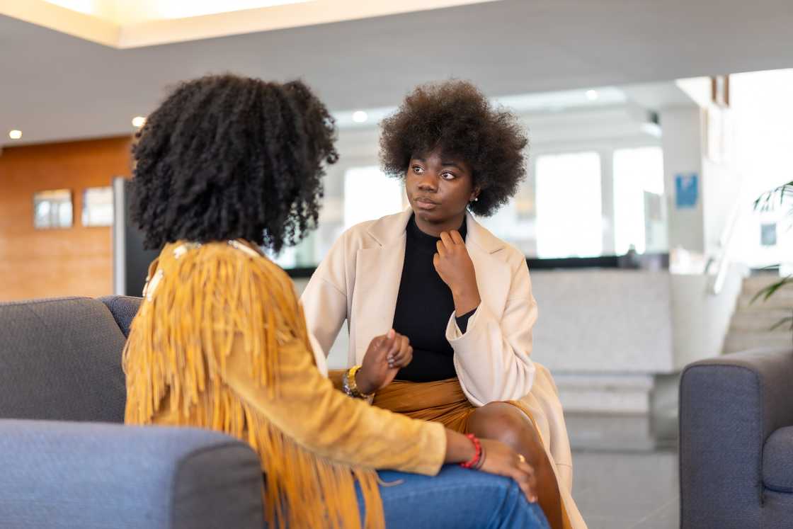 A woman expressing her concerns to another woman A woman expressing her concerns to another woman