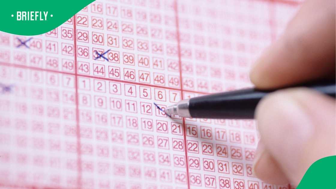 An individual ticking multiple numbers on the lotto ticket.