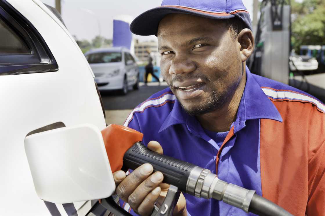 A petrol attendant filling up a car's tank.