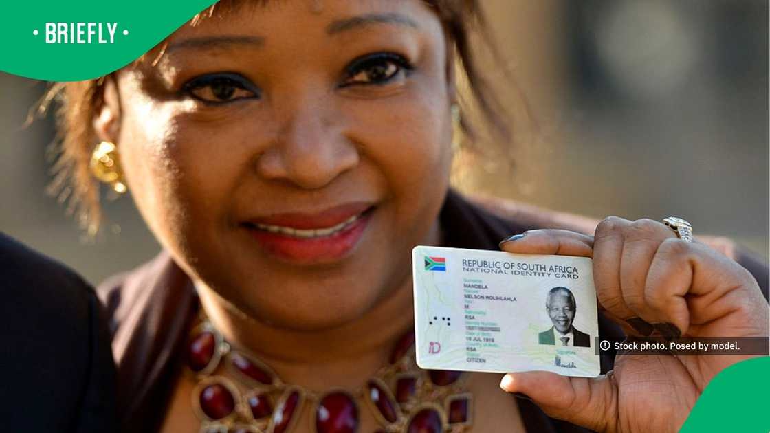 A woman holding a smart ID Card of Nelson Mandela A woman holding a smart ID Card of Nelson Mandela