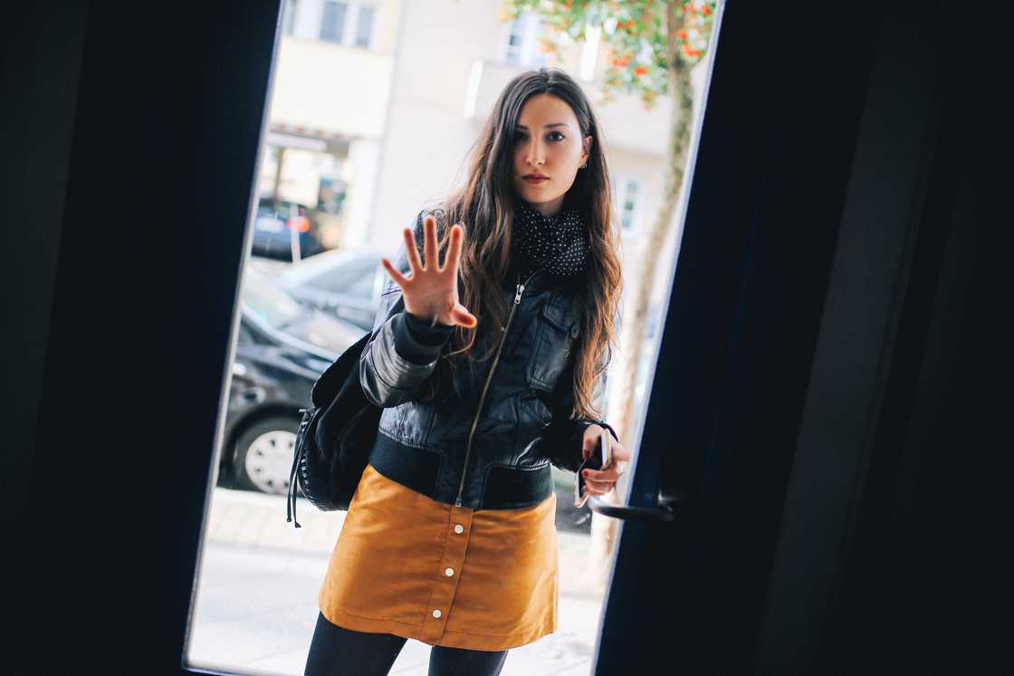Woman stands at a door.