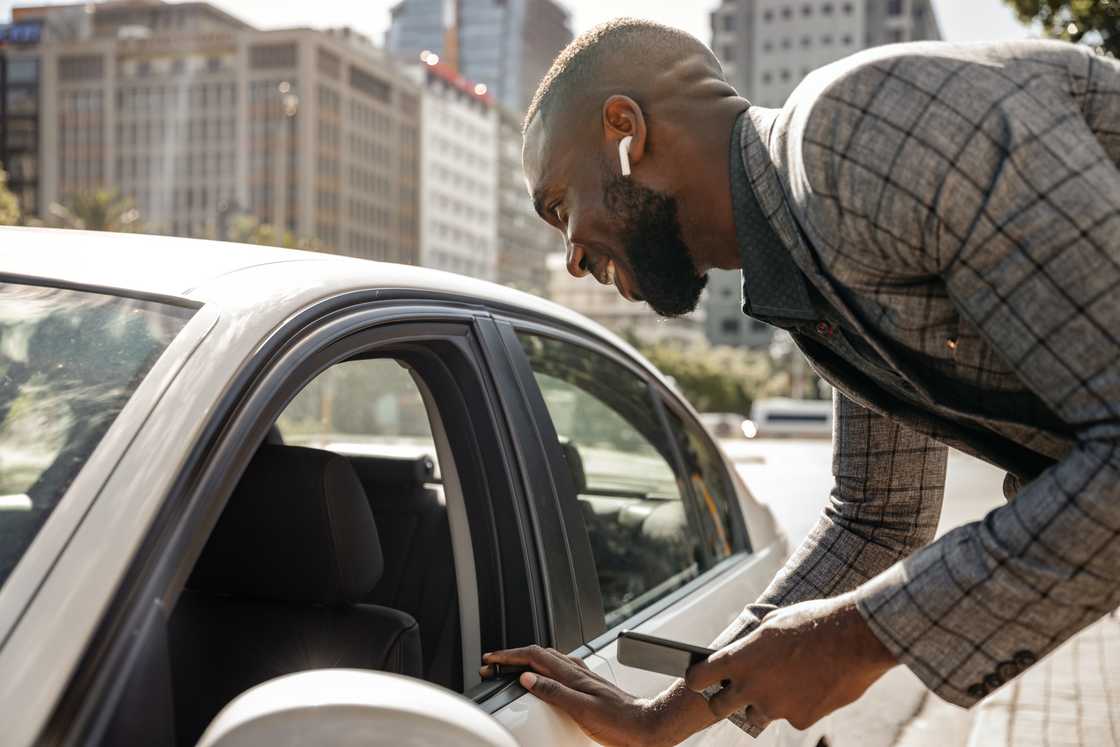 A man talking to a driver through a car window