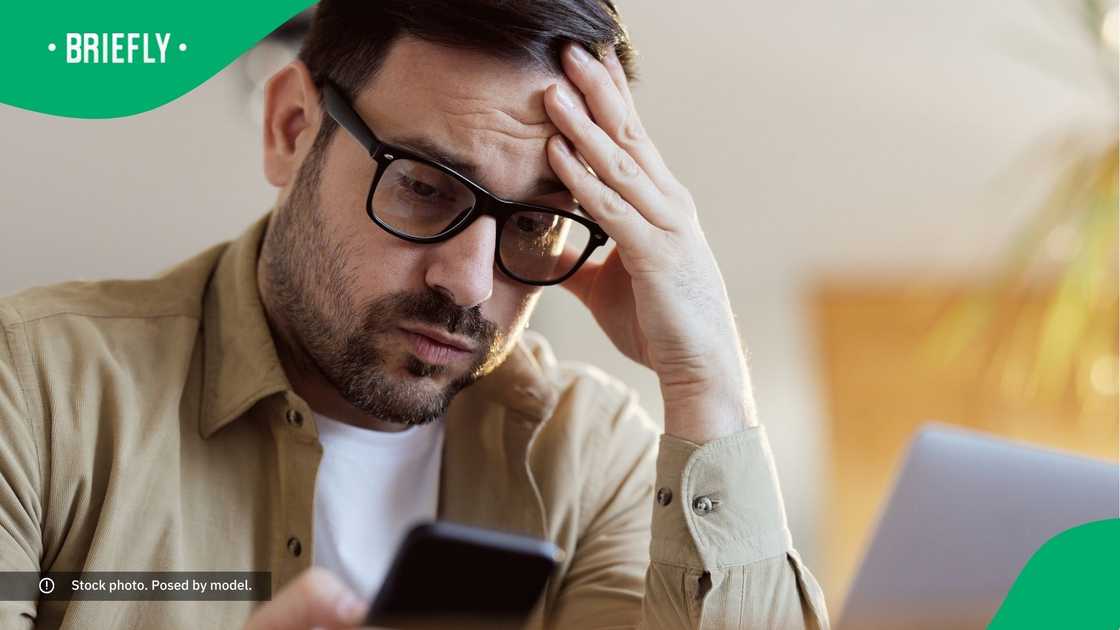A man looking at his phone with worry. A man looking at his phone with worry.