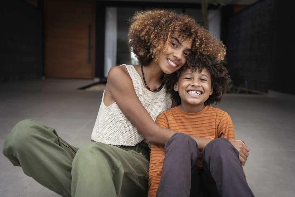 A young woman and her brother embracing