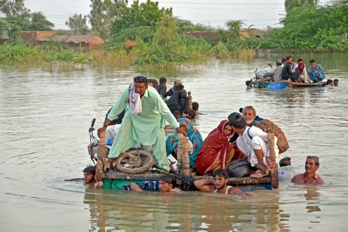 Villagers flee their homes on upturned wooden beds in the Jaffarabad district of Balochistan on Thursday