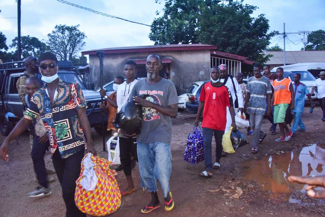 Detainees walk with their belongings