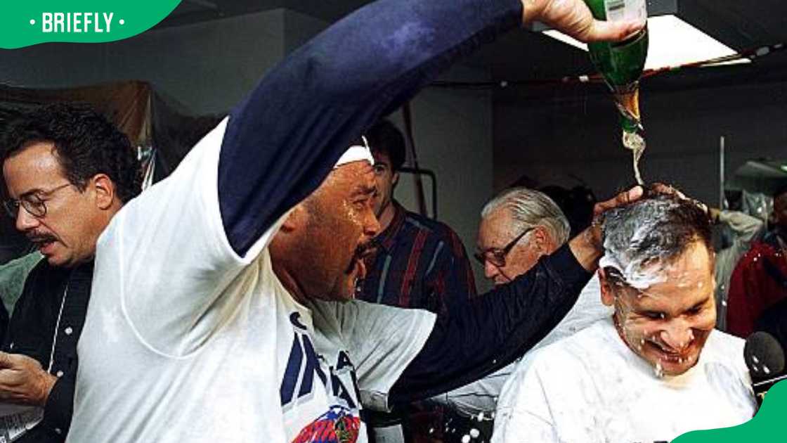 Jose Mesa pouring champagne over Omar Vizquel's head
