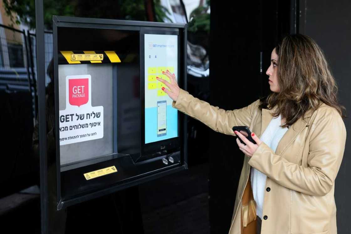 The robot toils in the custom-made space, fitted with a streetside hatch for couriers and shoppers to collect online orders The robot toils in the custom-made space, fitted with a streetside hatch for couriers and shoppers to collect online orders