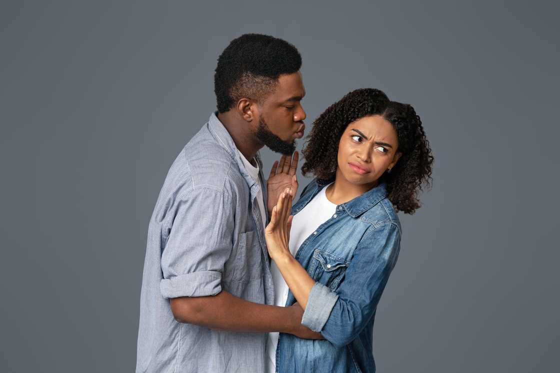 Angry woman rejecting a kiss from a man