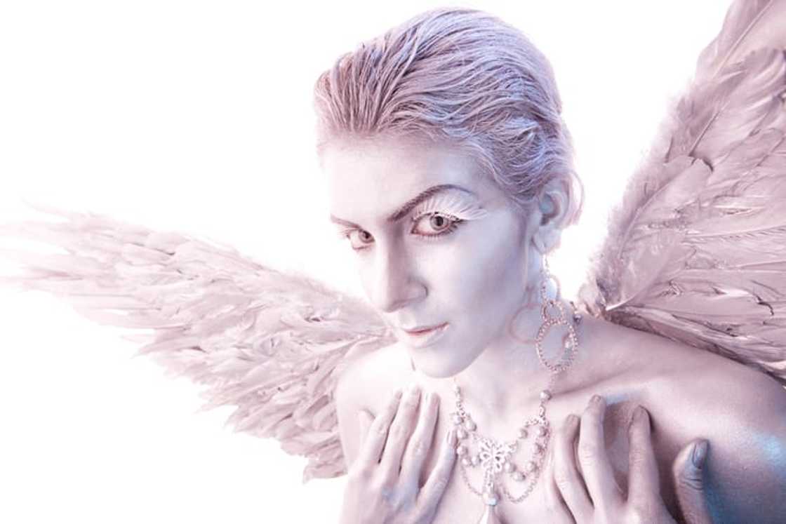A woman's body painted in silver as a heavenly angel A woman's body painted in silver as a heavenly angel
