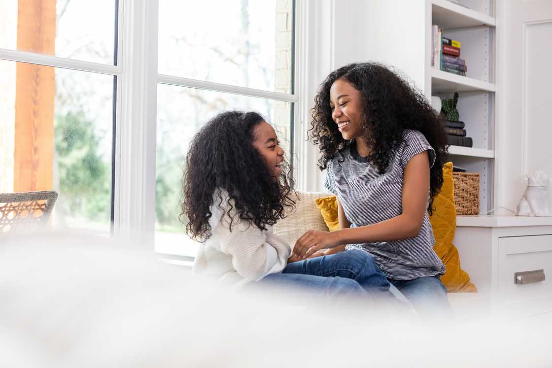 Two siblings talking indoors