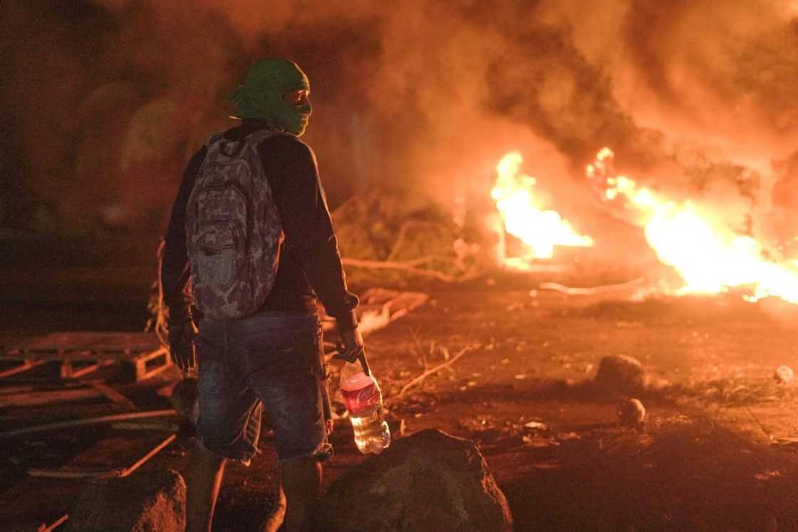 A demonstrator stands in front of burning tires during a protest against fuel prices in Santiago de Veraguas