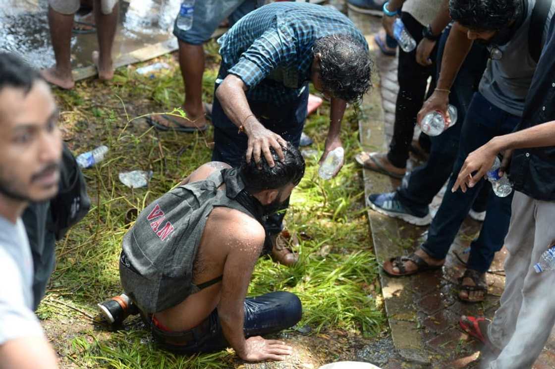 Protesters guided friends or strangers blinded by the smoke to safety behind the cover of a wall, helping to flush their eyes with fluid Protesters guided friends or strangers blinded by the smoke to safety behind the cover of a wall, helping to flush their eyes with fluid