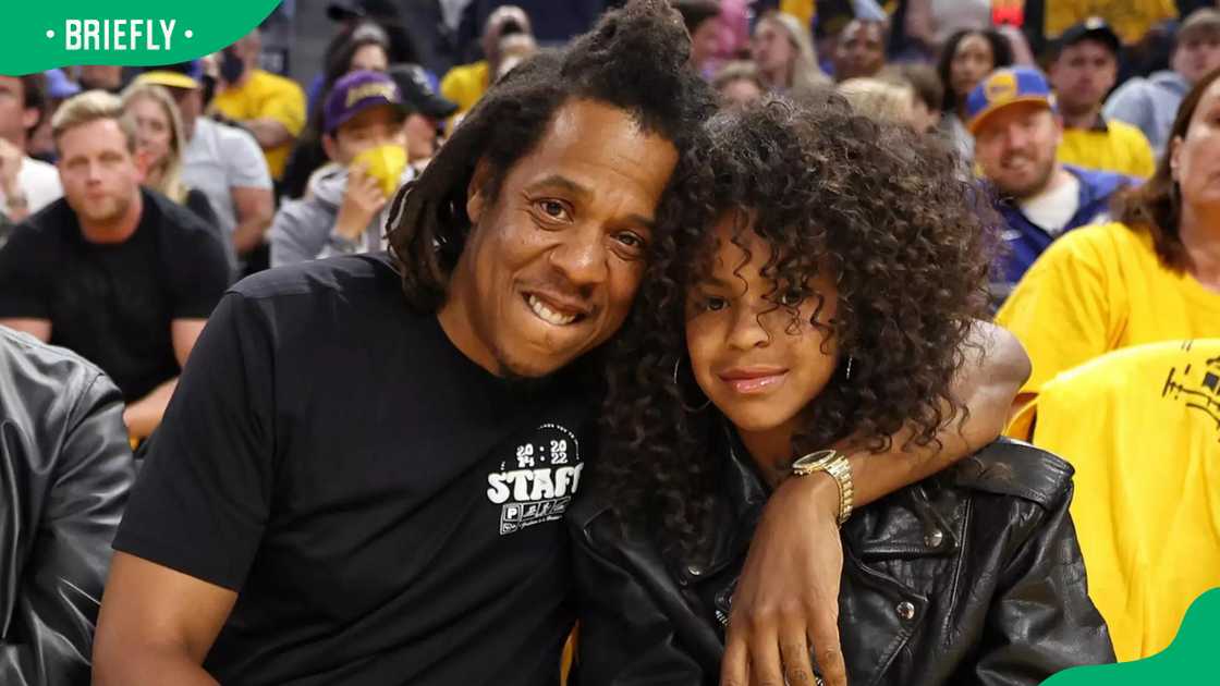 Jay-Z looks on with his daughter Blue Ivy during a game Jay-Z looks on with his daughter Blue Ivy during a game