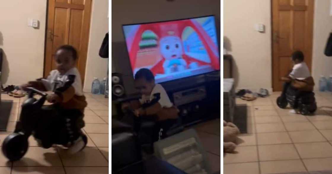 Kid playing with plastic bike inside house.