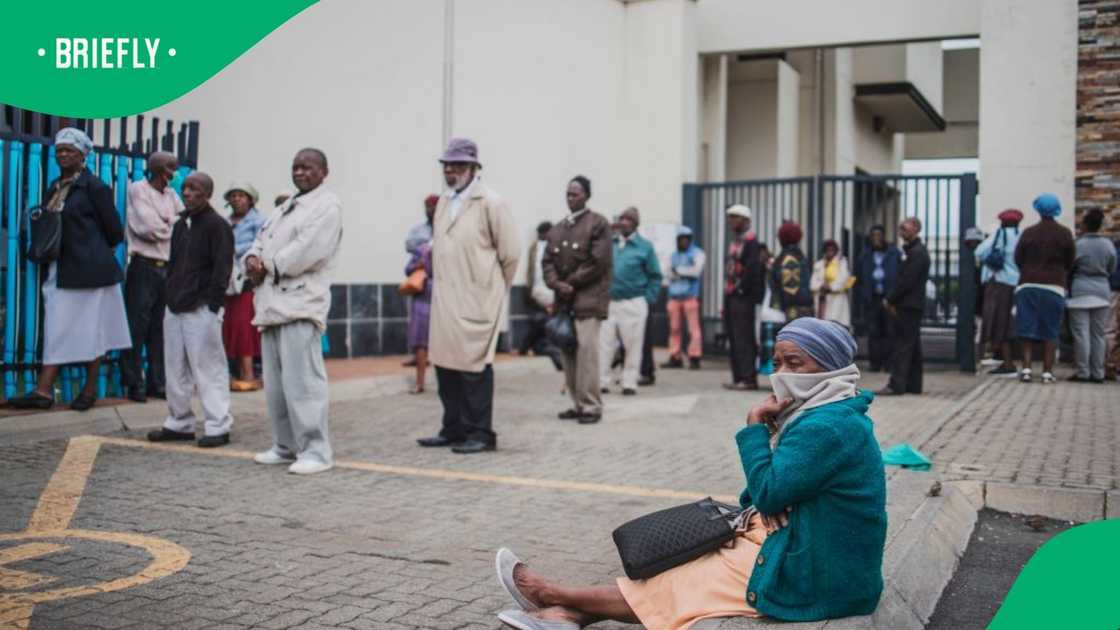 An elderly woman from Soweto, covers her mouth with a scarf while queuing at a SASSA (South African Social Security Agency) pay-point in Soweto on March 30, 2020