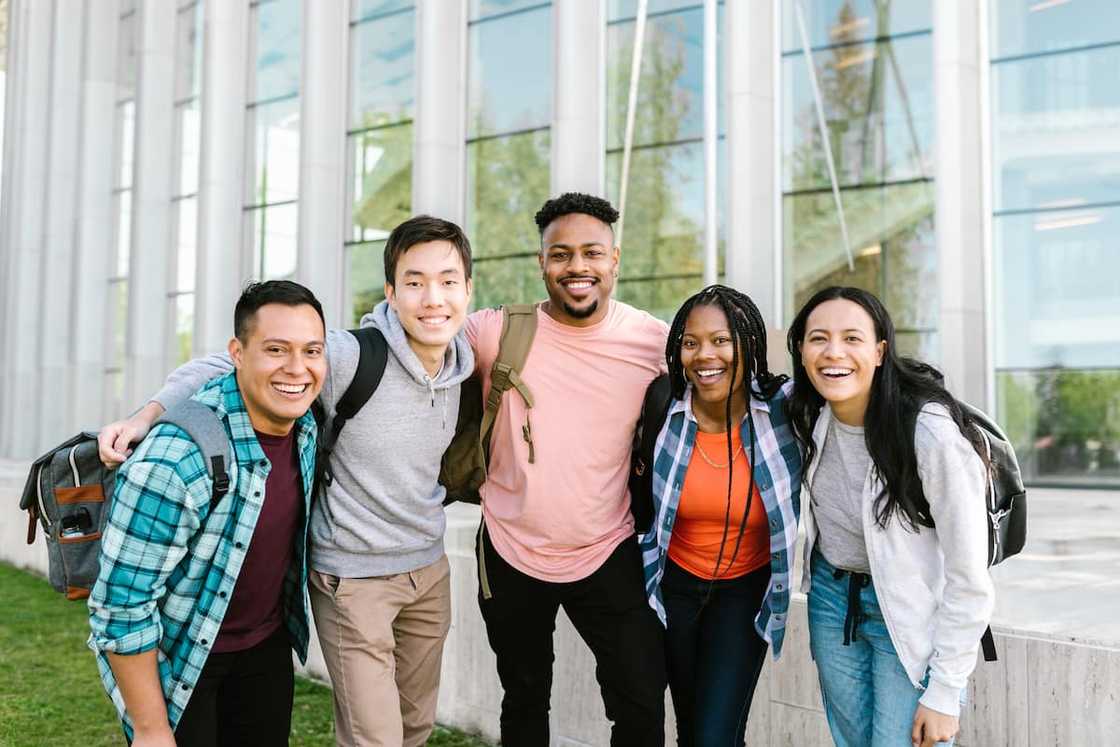 A group of five college students smiling for a picture A group of five college students smiling for a picture